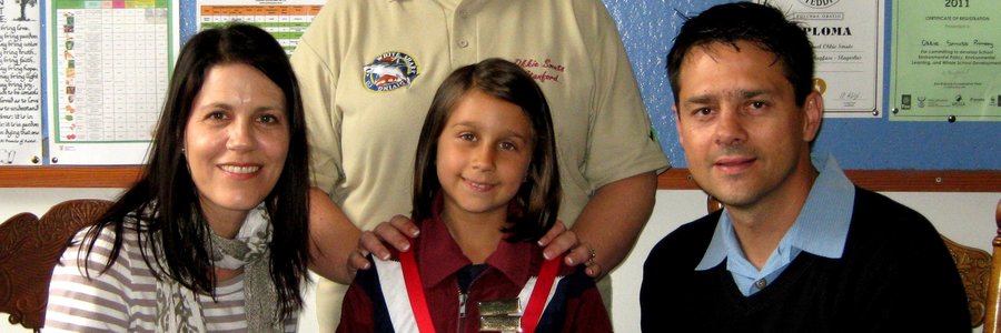 Voor vlnr is me Anushka Barkhuizen, Abigail Barkhuizen (Gr 2) en mnr Jakobus Barkhuizen, met die onderwyseres, me Liekie Lourens agter